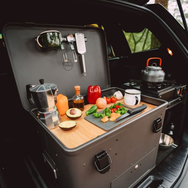 Kempinková kuchyně Layzee Kitchenbox se zeleninou v kufru auta.